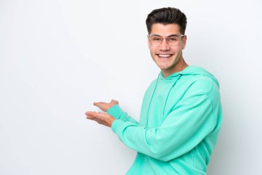 Beyaz fırında izole edilmiş yakışıklı beyaz adam, davet edilmek için ellerini yana uzatıyor.