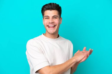 Genç, yakışıklı, beyaz bir adam mavi fırında yalnızdı ve alkışlıyordu.