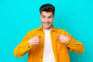 Young handsome caucasian man isolated on blue bakcground with surprise facial expression