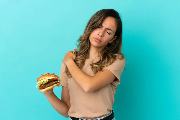 Jeune Femme Tenant Hamburger Sur Fond Isolé Souffrant Douleur Épaule — Photo