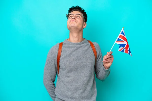 Ung Kaukasisk Man Som Håller Brittisk Flagga Isolerad Blå Bakgrund — Stockfoto