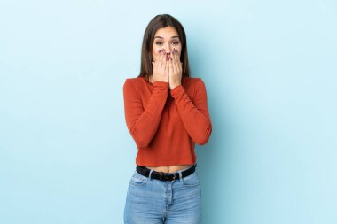 Genç beyaz kadın mavi arka planda izole edilmiş mutlu ve gülümseyen elleri ve ağzı kapalı.