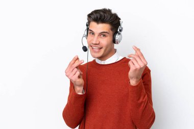 Beyaz arka planda izole edilmiş kulaklıkla çalışan beyaz pazarlamacı beyaz adam para hareketi yapıyor.