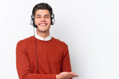 Beyaz arka planda izole edilmiş bir kulaklıkla çalışan beyaz pazarlamacı bir fikir sunarken aynı zamanda gülümsüyor.