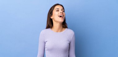 Kafkasyalı genç bir kadın soyutlanmış arka planda gülüyor.