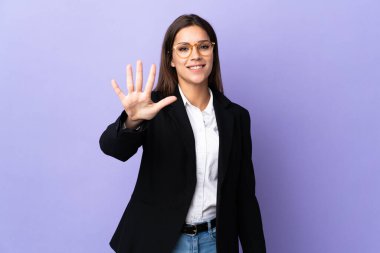 Mor arka planda izole edilmiş iş kadını parmaklarıyla beşi sayıyor