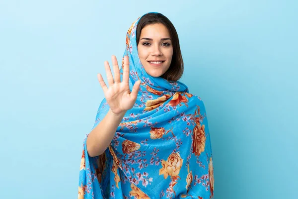5本指で数える青の背景に隔離された伝統的な衣装を持つ若いモロッコ女性 — ストック写真