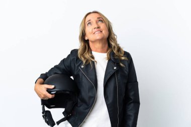 İzole edilmiş beyaz arka plan üzerinde orta yaşlı motosikletçi yukarı bakarken bir fikir düşünüyor