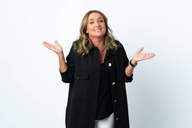 Orta yaşlı sarışın kadın soyutlanmış beyaz arka planda şüpheli hareketler yapıyor.