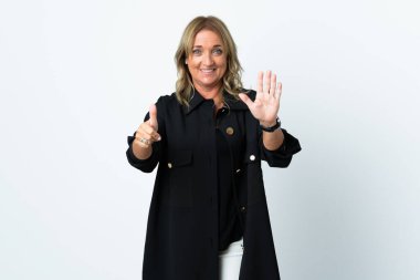 Orta yaşlı sarışın kadın izole edilmiş beyaz arka planda altı parmaklı sayıyor.