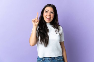 Mor arka planda izole edilmiş genç beyaz kadın çözümü bulmak için parmağını kaldırıyor.