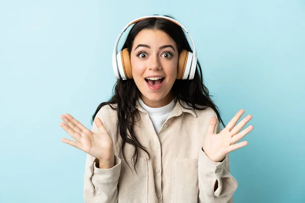 Νεαρή Καυκάσια Γυναίκα Απομονωμένη Μπλε Φόντο Έκπληκτη Και Ακούγοντας Μουσική — Φωτογραφία Αρχείου