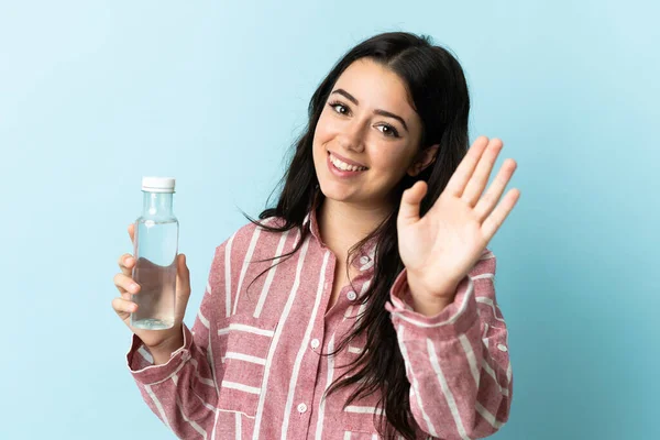 Mujer Joven Con Agua Aislada Sobre Fondo Azul Saludando Con — Foto de Stock