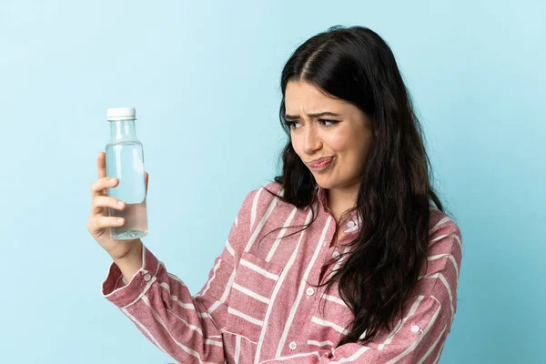 Jovem Com Uma Água Isolada Fundo Azul Com Expressão Triste — Fotografia de Stock