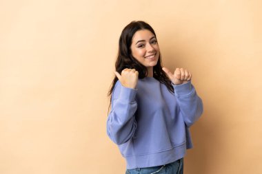 Tecrit edilmiş geçmişi olan beyaz bir kadın bir ürünü sunmak için kenarı işaret ediyor.