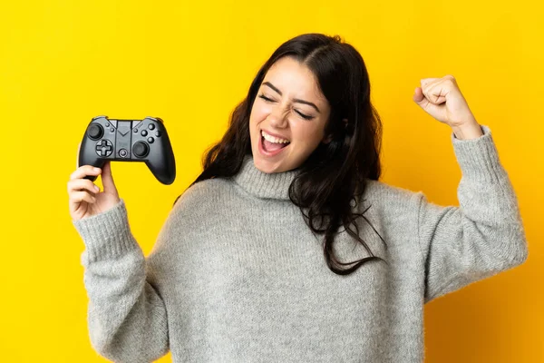 Mujer Jugando Con Controlador Videojuegosaislado Sobre Fondo Amarillo Celebrando Una —  Fotos de Stock