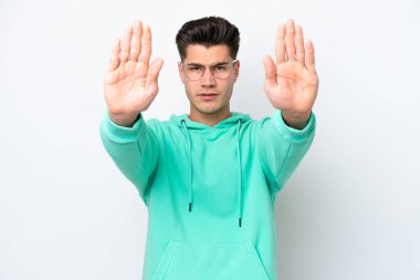 Beyaz fırında izole edilmiş yakışıklı beyaz bir adam dur hareketi yapıyor ve hayal kırıklığına uğruyor.