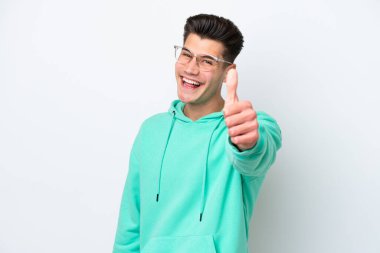 Beyaz tenli yakışıklı beyaz bir adam, beyaz bir fırında izole edildi. Başparmakları havada, çünkü iyi bir şey oldu.