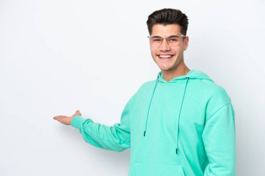 Beyaz fırında izole edilmiş yakışıklı beyaz adam, davet edilmek için ellerini yana uzatıyor.