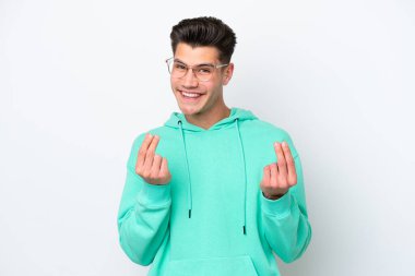 Beyaz fırında izole genç yakışıklı beyaz adam para jesti yapıyor