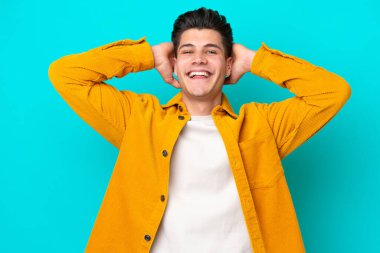 Genç, yakışıklı, beyaz bir adam mavi fırında yapayalnız gülüyor.