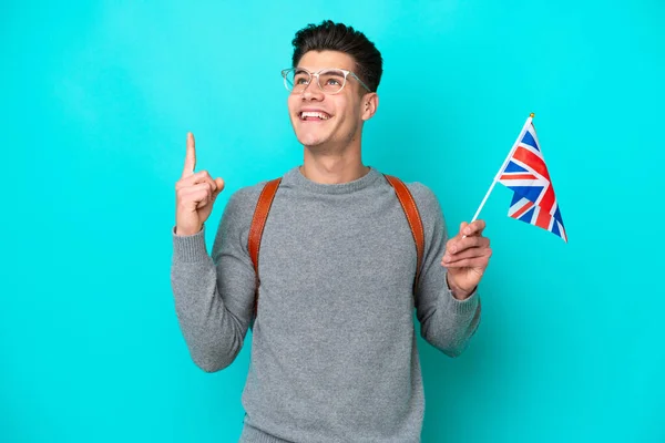 年轻的高加索人举着一面英国国旗 蓝色背景隔离 这说明了一个伟大的想法 — 图库照片