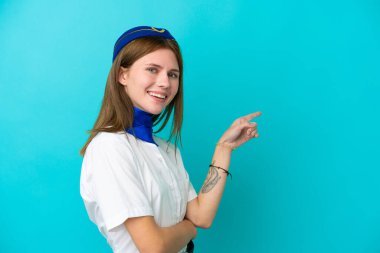 Uçak hostesi İngiliz kadın, mavi arka planda izole edilmiş.