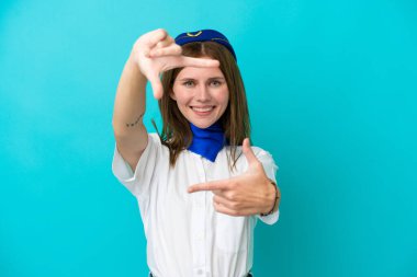 Uçak hostesi İngiliz kadın mavi arka planda izole edilmiş, odaklanan yüz. Çerçeve sembolü