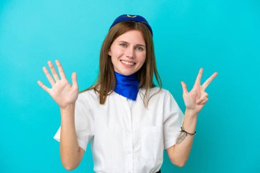 Uçak hostesi İngiliz kadın mavi arka planda izole edilmiş, parmaklarıyla sekiz kişi sayıyor.