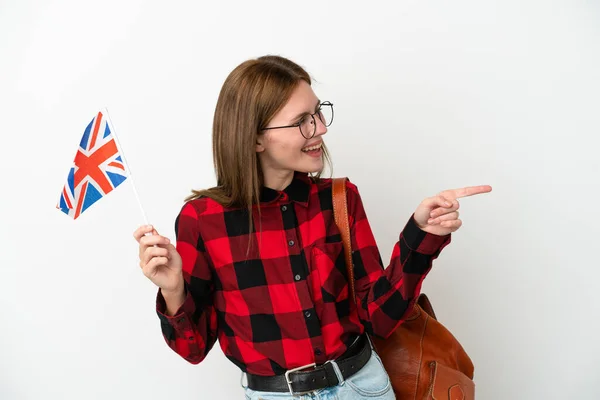 Mladá Žena Drží Vlajku Spojeného Království Izolovanou Modrém Pozadí Ukazující — Stock fotografie