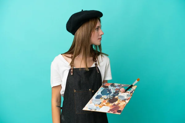 Młoda Artystka Angielski Kobieta Trzyma Paletę Odizolowanych Niebieskim Tle Patrząc — Zdjęcie stockowe