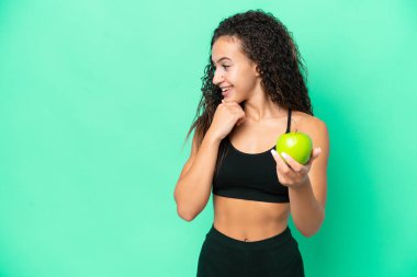 Yeşil arka planda soyutlanmış genç bir Arap kadın bir fikir ve bakış açısı düşünüyor.