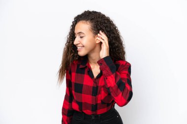 Genç bir Arap kadın, beyaz arka planda izole edilmiş bir şekilde elini kulağına koyarak bir şeyler dinliyor.