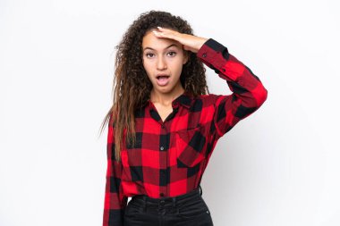 Beyaz arka planda izole edilmiş genç bir Arap kadın yan tarafa bakarken sürpriz jest yapıyor.