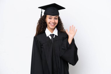 Genç üniversite mezunu Arap bir kadın beyaz arka planda izole edilmiş, mutlu bir ifadeyle selamlıyor.