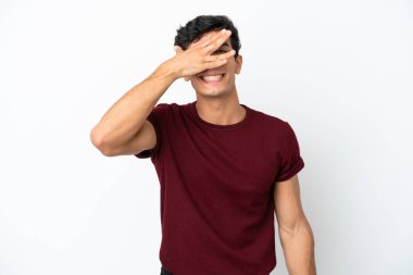 Arjantinli genç bir adam beyaz arka planda izole edildi. Gözlerini elleriyle kapadı ve gülümsedi.