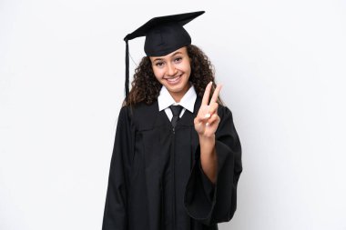 Genç üniversite mezunu Arap kadın beyaz arka planda izole edilmiş gülümsüyor ve zafer işareti gösteriyor.