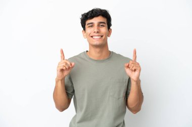 Beyaz arka planda izole edilmiş genç Arjantinli adam harika bir fikre işaret ediyor.