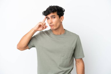 Genç Arjantinli bir adam beyaz arka planda izole edilmiş bir fikir düşünüyor.