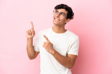 Pembe arka planda izole edilmiş genç Arjantinli adam işaret parmağıyla işaret etmek harika bir fikir.
