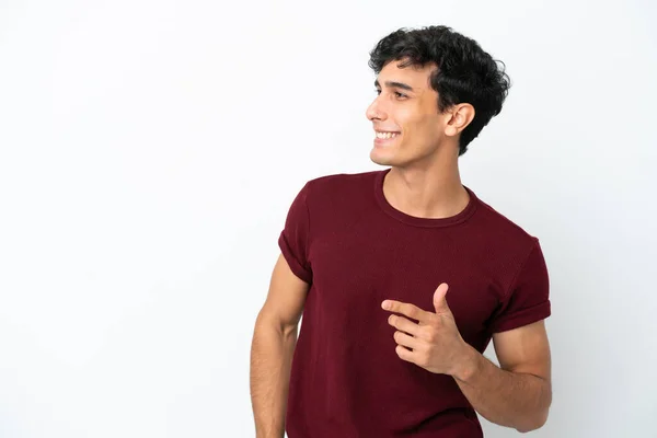 Молодой Аргентинский Мужчина Выделяется Белом Фоне Указывая Пальцем Сторону Представляя — стоковое фото