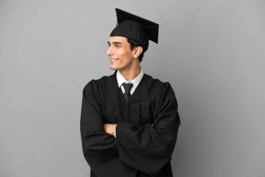 Arjantinli genç üniversite mezunu. Gri arka planda izole edilmiş.