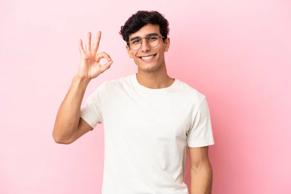 Молодой Аргентинский Мужчина Изолирован Розовом Фоне Показывая Знак Пальцами — стоковое фото