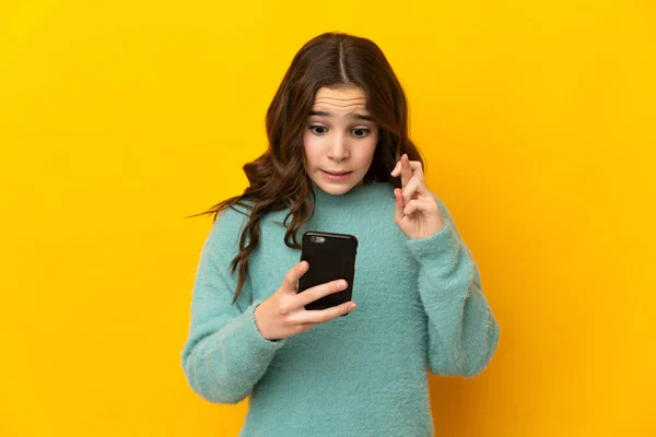 Μικρή Καυκάσιος Κορίτσι Απομονώνονται Κίτρινο Φόντο Χρησιμοποιώντας Κινητό Τηλέφωνο Δάχτυλα — Φωτογραφία Αρχείου