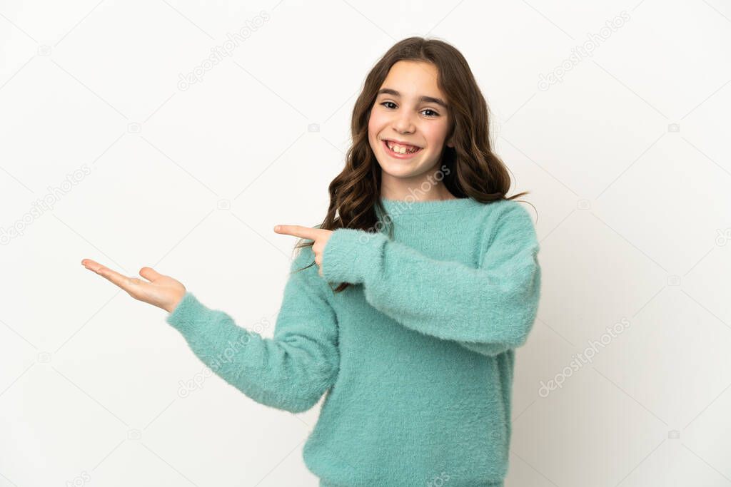 Little caucasian girl isolated on white background holding copyspace imaginary on the palm to insert an ad