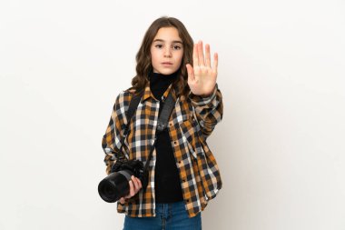 Arka planda izole edilmiş küçük fotoğrafçı kız dur hareketi yapıyor.