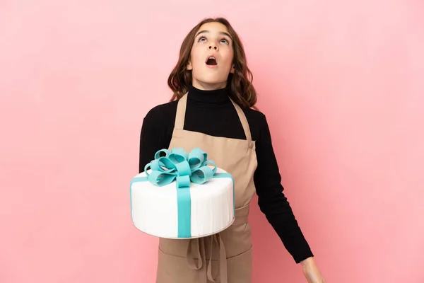 Kleine Konditorin Hält Eine Große Torte Isoliert Auf Rosa Hintergrund — Stockfoto