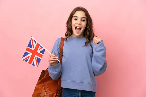 拿着英国国旗 身披粉色背景的小女孩庆祝获奖者的胜利 — 图库照片