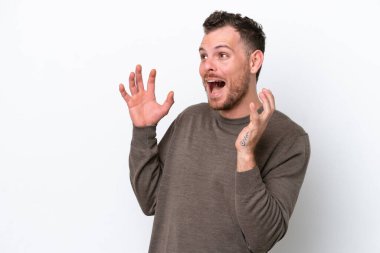 Genç Brezilyalı adam beyaz arka planda izole edilmiş, şaşırmış bir yüz ifadesi var.