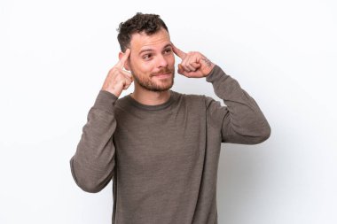 Genç Brezilyalı bir adam beyaz arka planda izole edilmiş. Şüpheleri ve düşünceleri var.